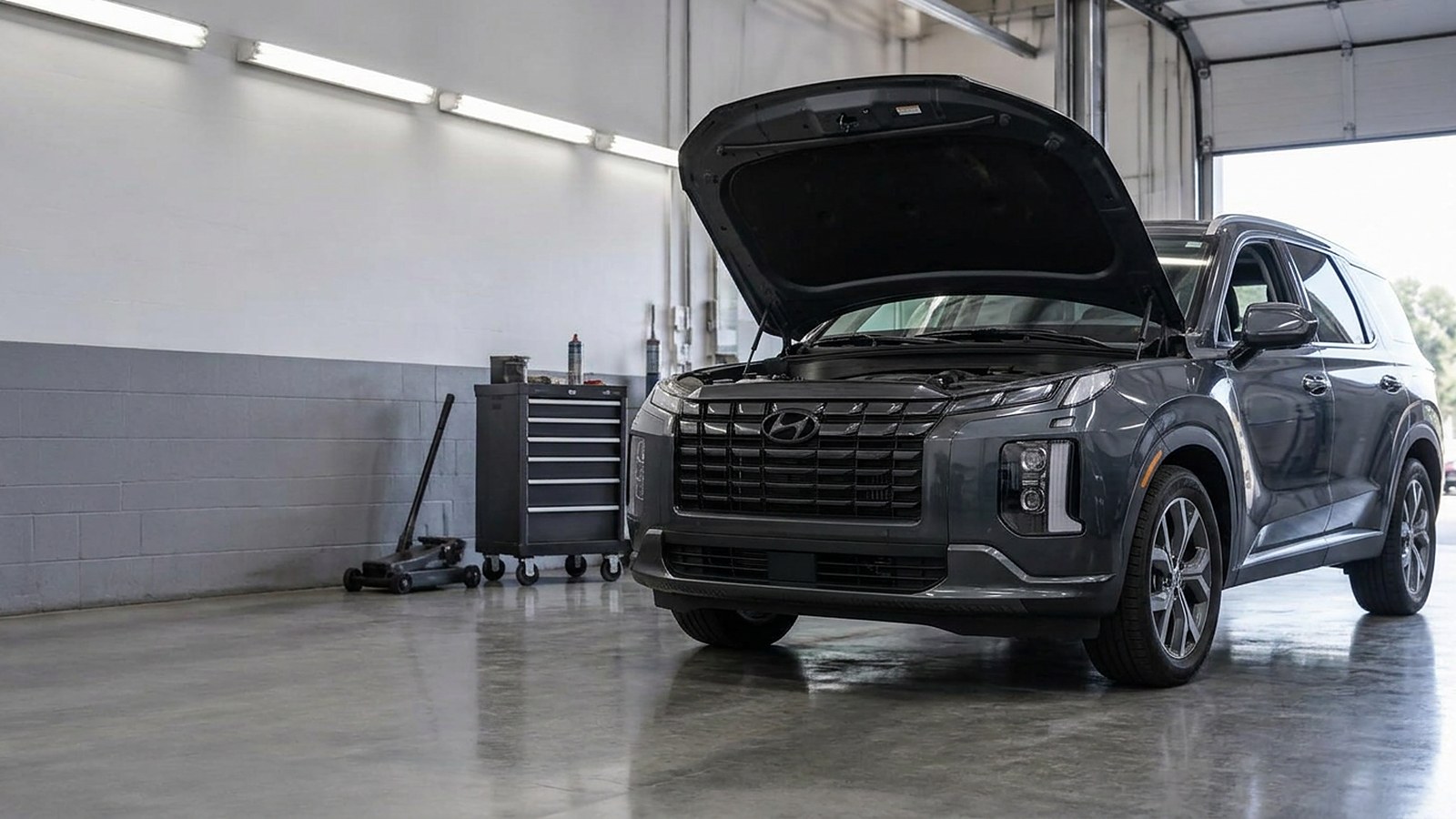 A used crossover with its hood open in a dealership service bay, evoking a repeated warranty repair.